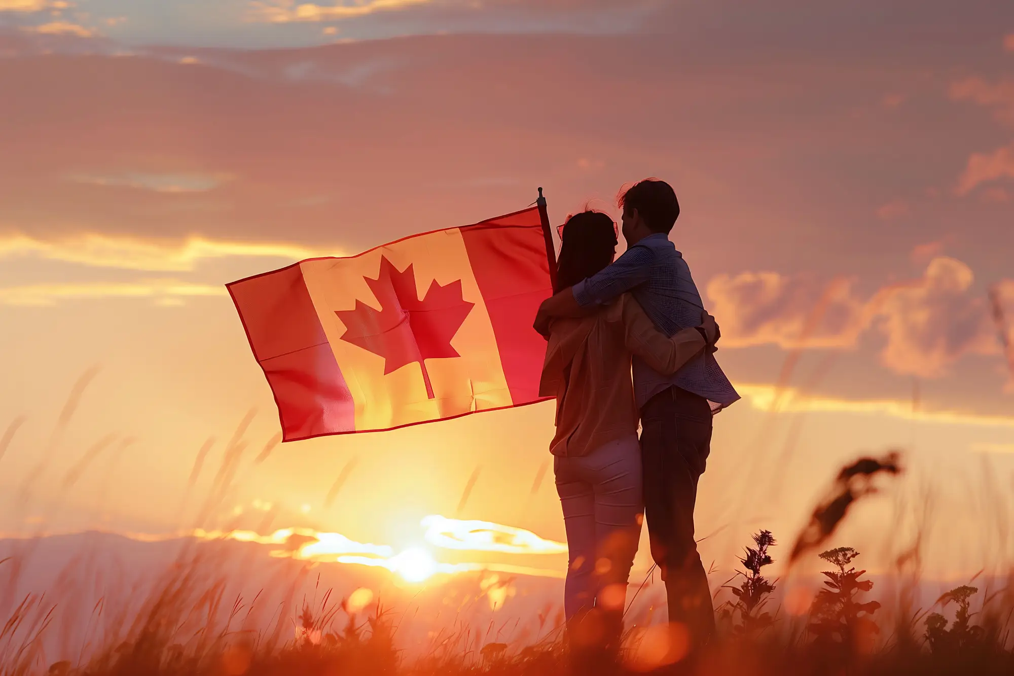 Couple holding Canadian flag during sunset, symbolizing Canada's welcoming atmosphere for immigrants.