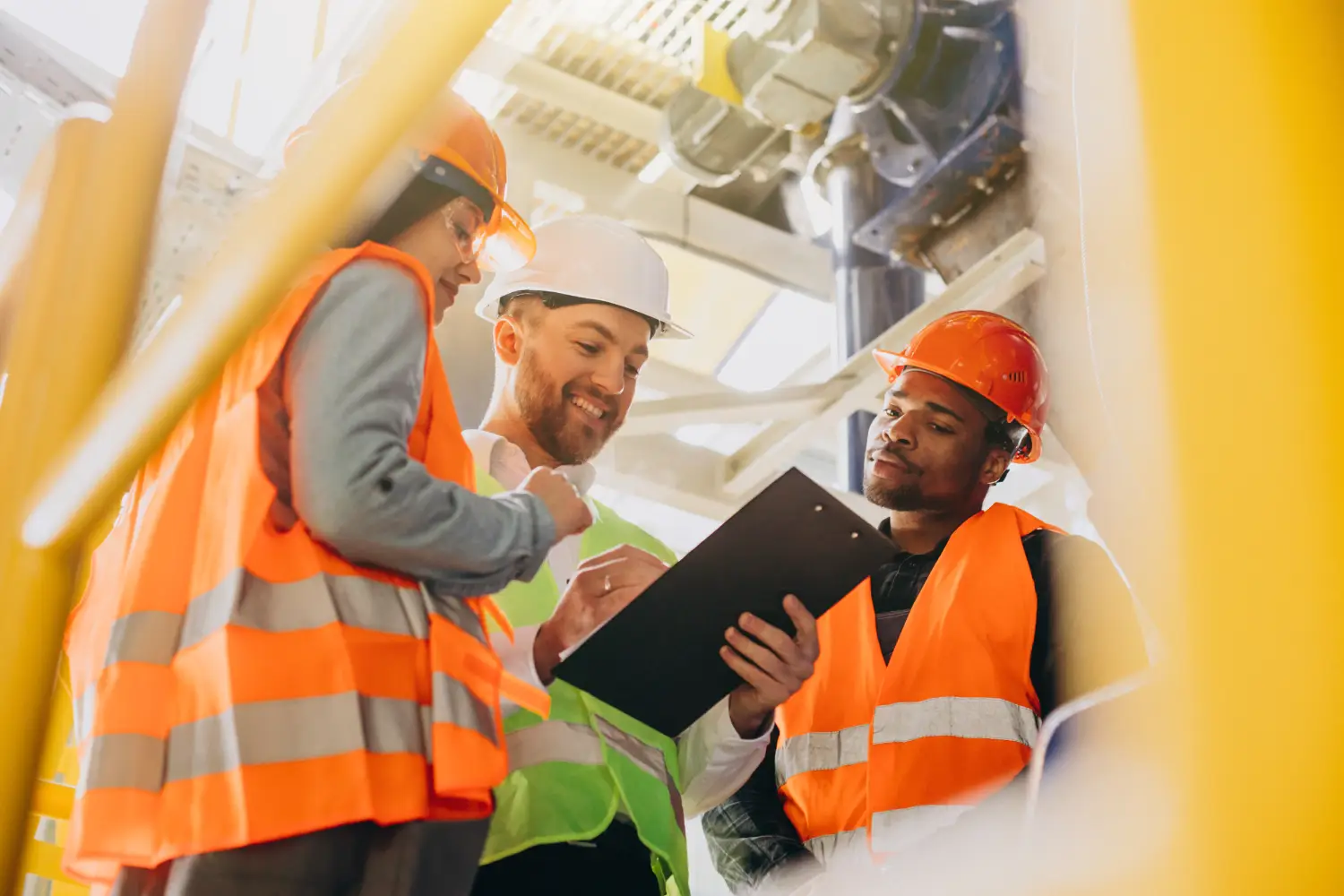 Group of construction workers in safety gear reviewing documents, representing Canada’s program for temporary foreign workers to gain permanent residency 